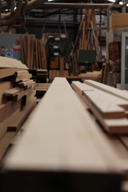 Long hardwood timber planks and beams stored in the Marrickville Joinery workshop, representing the quality materials used in custom joinery production. Hardwood Timber Planks in Workshop