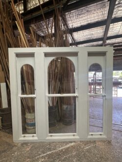 White-painted timber door with an elegant arched top section and raised panel design, handcrafted at Marrickville Joinery.