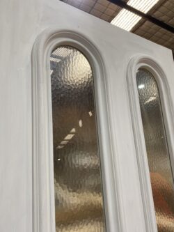 Elegantly curved arched timber door section with shaped glass panes, showcasing precision craftsmanship from Marrickville Joinery.