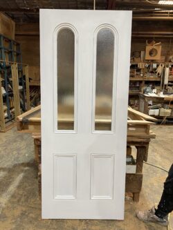 Pair of white-painted bifold French doors with tall narrow glass panes, suitable for contemporary interiors, handcrafted at Marrickville Joinery.