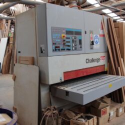Heavy-duty Challeng-brand industrial wide belt sanding machine used in the workshop for precision timber surface preparation.