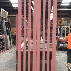 Pink painted vertical batten screen panels in the workshop, crafted for use as privacy screens or decorative room dividers. Painted Vertical Batten Screens