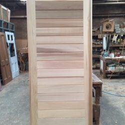 Unfinished heritage four-panel solid timber door, awaiting final sanding and finishing.