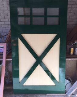 Decorative timber panel featuring a bold X-cross motif, painted in green and white — suited to heritage gates or feature doors.