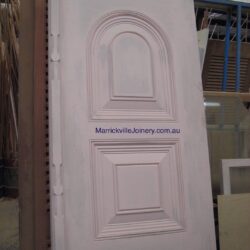 Heritage solid timber door with arched top panel and raised moulding, showcasing traditional Australian joinery craftsmanship.