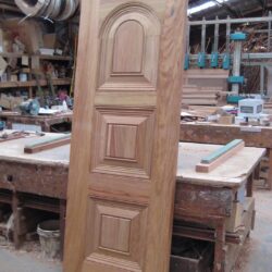 Solid timber heritage door with a prominent arched top panel, finished in a warm stained tone.