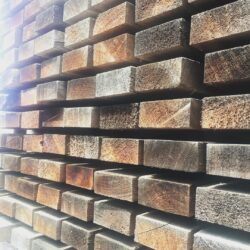 Rows of timber weatherboard or cladding panels stored in the workshop, ready for use in heritage renovation projects.