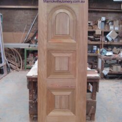 Heritage timber door with decorative raised panel moulding detail, showing traditional joinery craftsmanship.