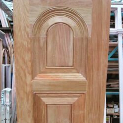 Heritage solid timber door with a distinctive arched top panel, shown in the workshop prior to finishing.