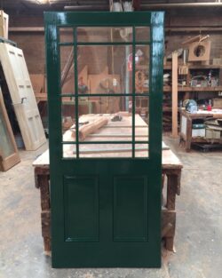 Workshop scene showing heritage windows and door components in various stages of construction.