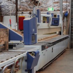 Large blue flat-bed CNC routing machine in the workshop, used for precision cutting of timber profiles and decorative elements. CNC Router Machine