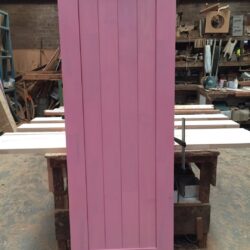 Heritage doorway featuring a classical decorative pediment or crown detail above, shown in pink painted finish.