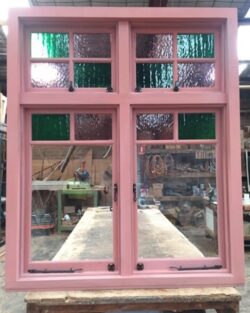 Heritage timber door featuring multi-coloured stained glass panels arranged in a traditional leadlight design.