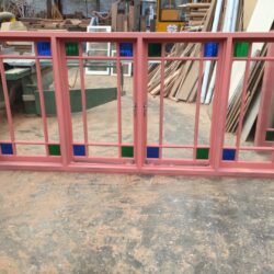 Pink painted balustrade or fence panel with inserted glass sections, a heritage-style feature for stairways or verandahs. Pink Balustrade with Glass Panels
