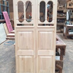 Heritage timber door featuring two narrow vertical oval-shaped glazing units, a traditional decorative design element.