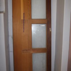 Plain heritage timber door with a single large raised panel in natural finish, showing clean traditional joinery.