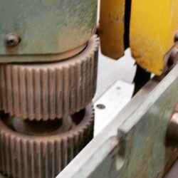 Close-up of a vintage cast iron gear or wheel mechanism from workshop machinery, showing the heritage equipment used in joinery.