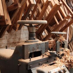 Workshop drill press or boring machine surrounded by sawdust debris, capturing the active production environment. Workshop Drill Press with Sawdust