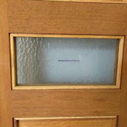 Rectangular frosted glass panel set within a natural timber frame, showing a clean modern glazing insert for heritage-style doors.