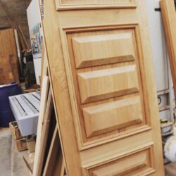 Close-up of a heritage timber door panel showing the characteristic raised rectangular detail and profiled moulding edges.