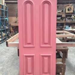 Two pink painted heritage panel doors displayed side by side, showing a matching pair for a double doorway application.