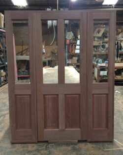 Heritage double door in dark-stained timber with multiple glass panes arranged in a traditional pattern, ideal for period home entry.