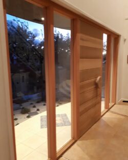 Natural timber heritage door installed in a hallway setting with sidelights, showing how the finished product looks in a domestic interior.