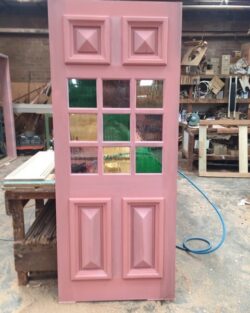 Heritage timber door featuring decorative coloured glass panels, combining traditional panel door design with art glass inserts.