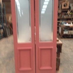 Tall slender pink painted door with narrow frosted glass inserts, combining a heritage painted finish with a modern privacy glass detail.